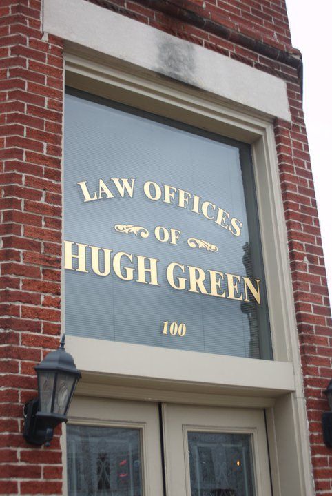 A brick building with a window that says law offices of hugh green