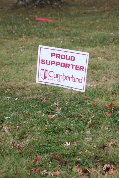 A proud supporter sign is sitting in the grass.