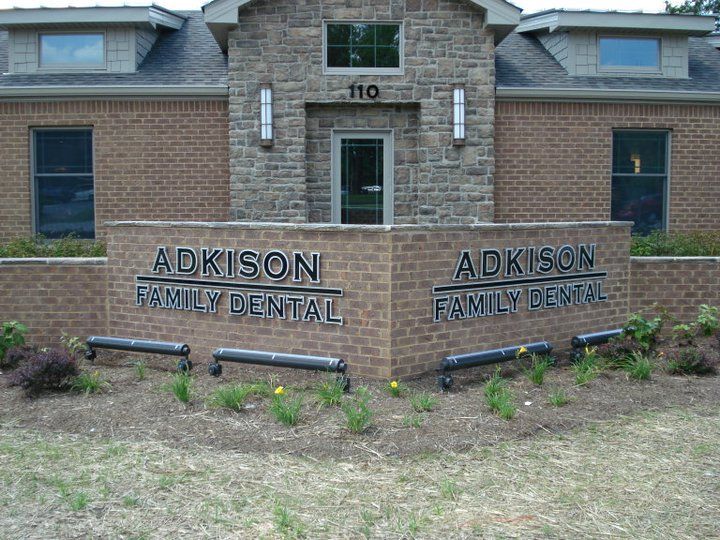 A brick building with a sign that says adkinson family dental