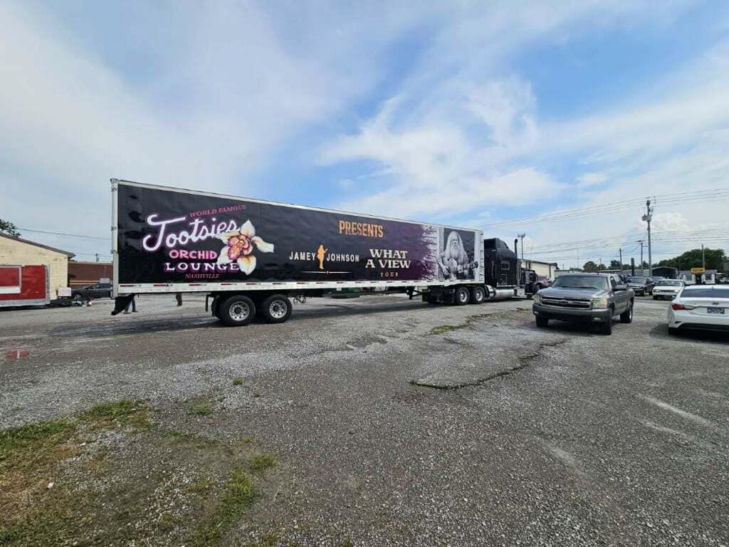 A trailer is parked in a parking lot next to a building.