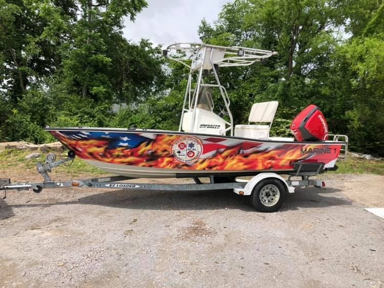 A boat with flames painted on it is on a trailer.