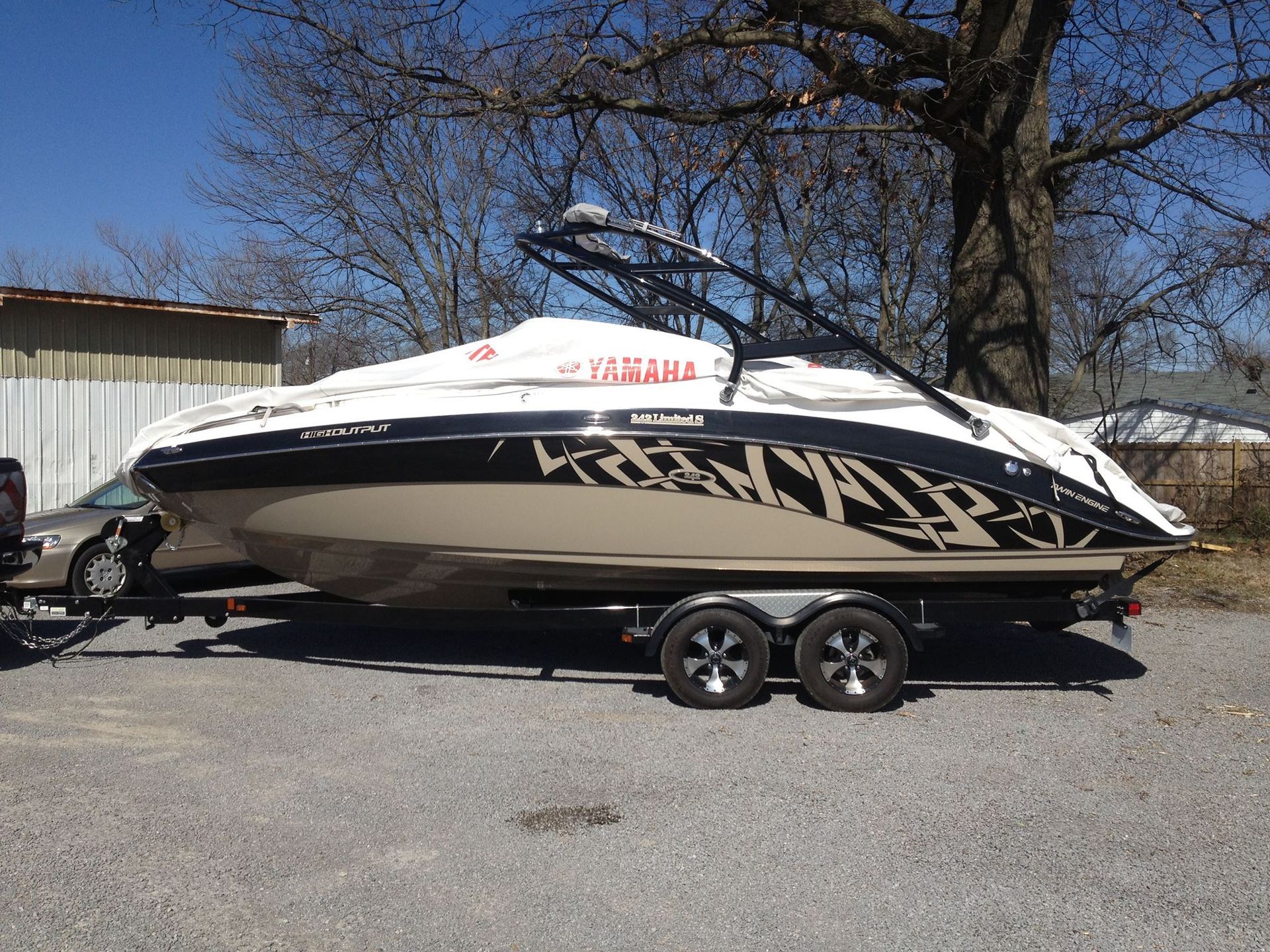 A boat is parked on a trailer in a parking lot.