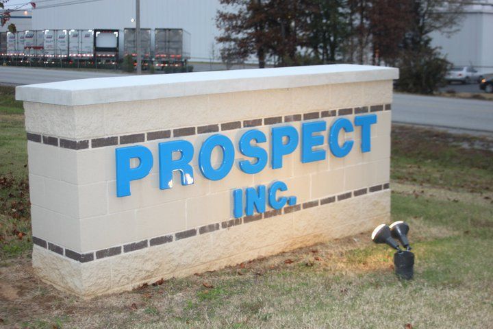 A white sign that says prospect inc. in blue letters