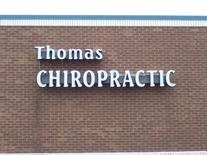 A thomas chiropractic sign on a brick wall