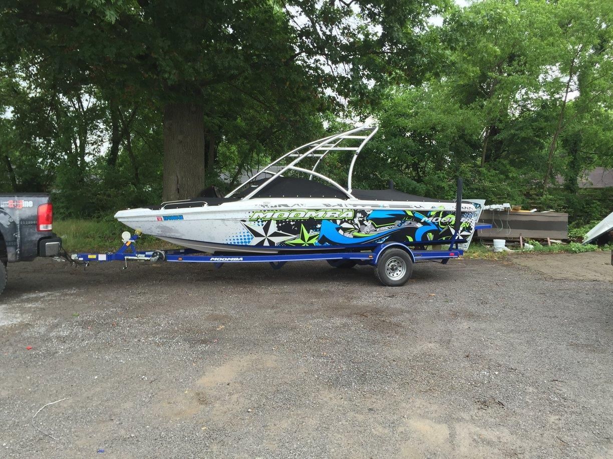 A boat is on a trailer in a parking lot.