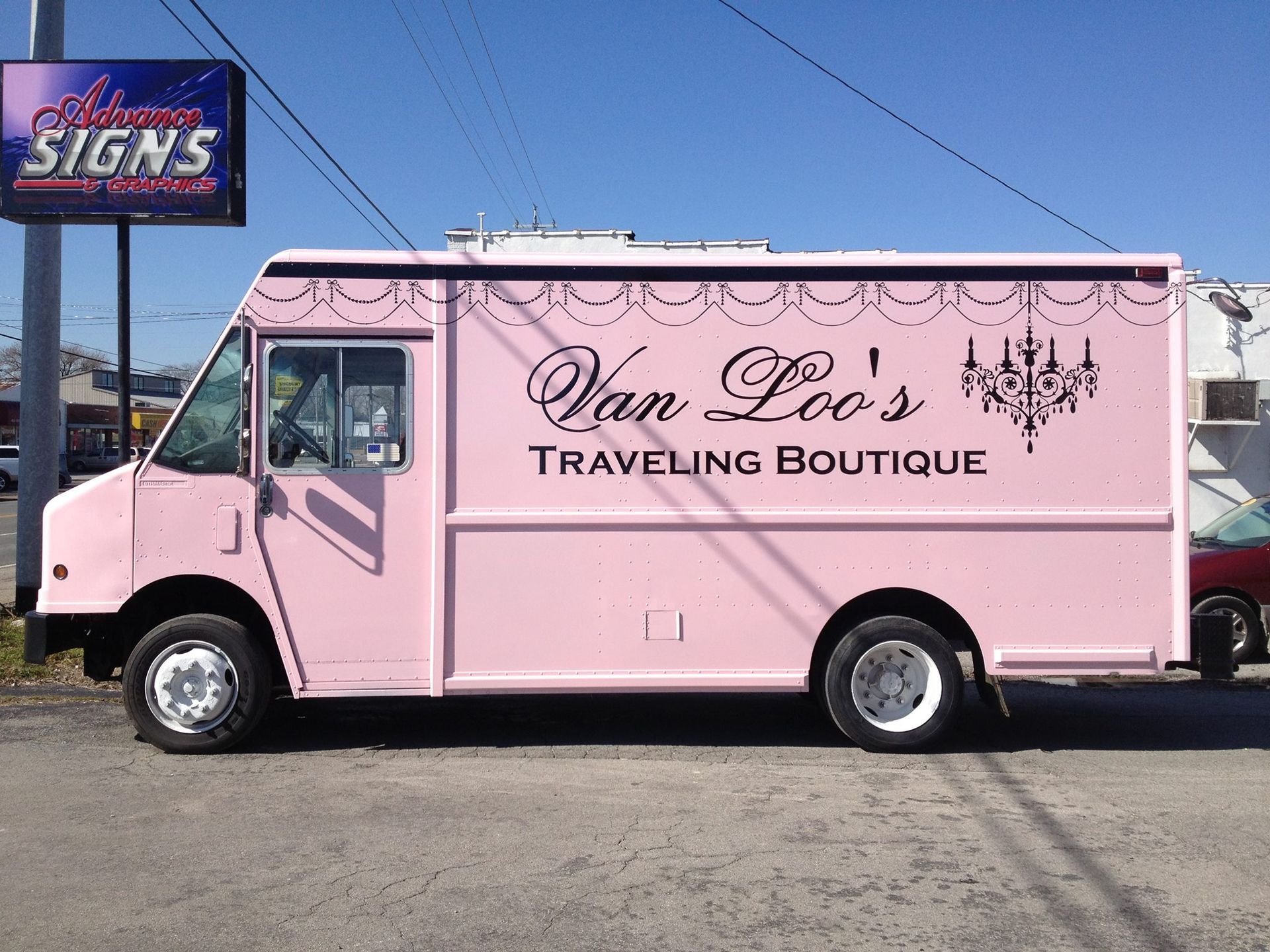 A pink van that says van loo 's traveling boutique