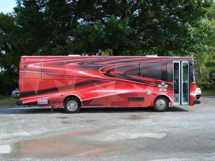 A large red bus is parked in a parking lot
