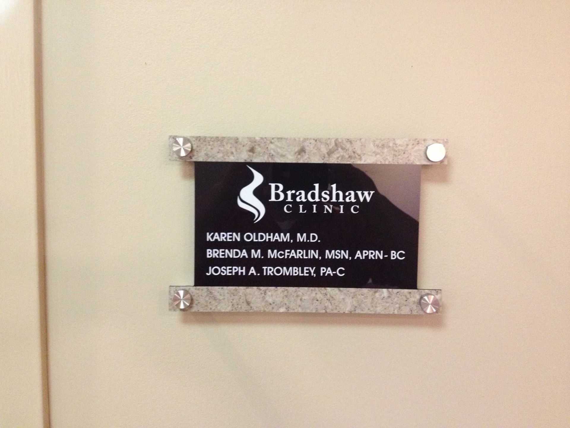 A sign for bradshaw clinic hangs on a wall