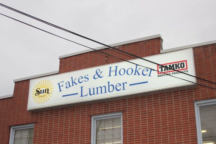 A brick building with a sign that says fakes & hooker lumber