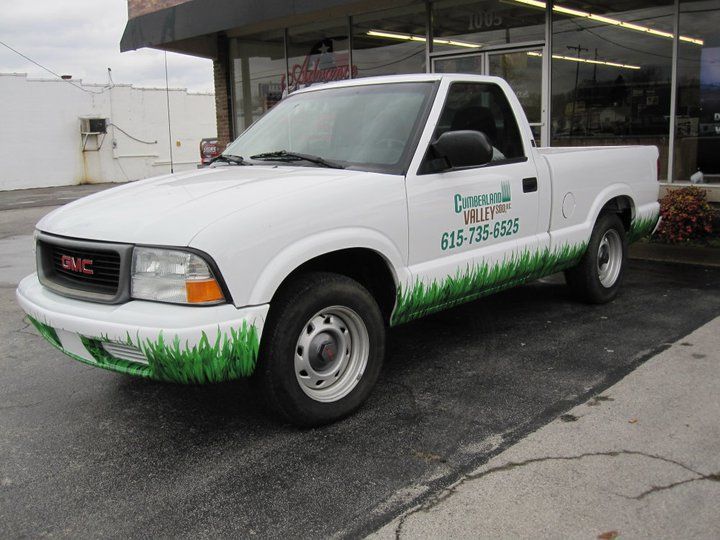 A white gmc truck is parked in front of a building