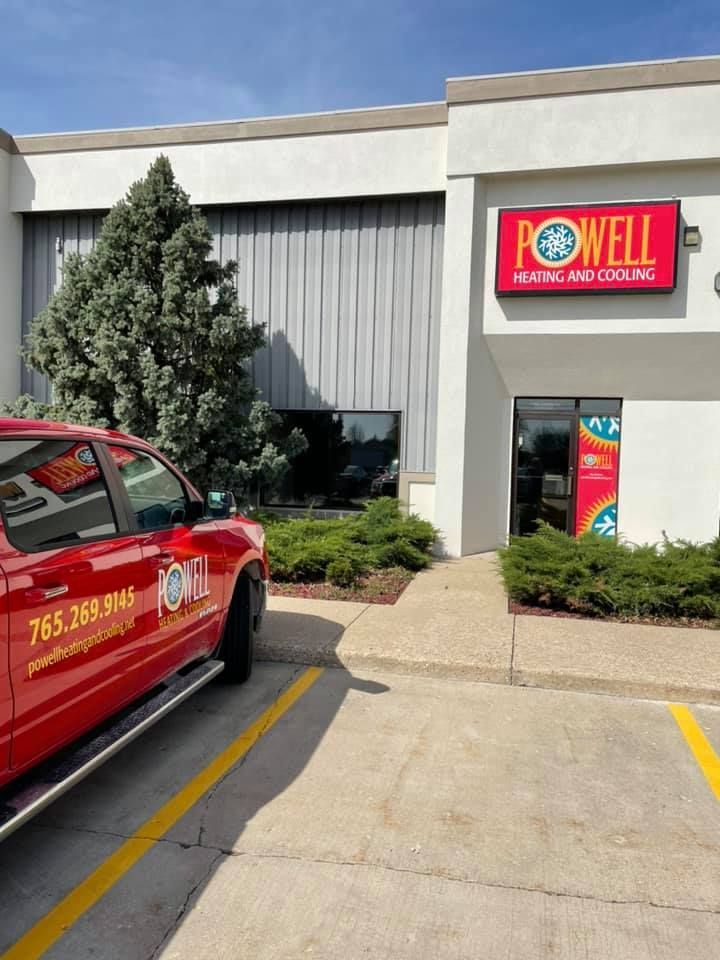 A red truck is parked in front of a powell building.