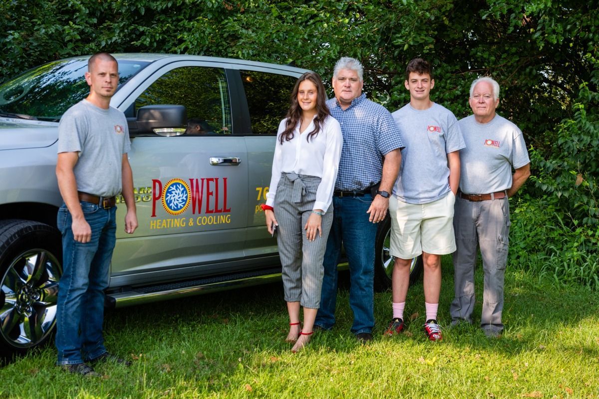 A group of people standing in front of a truck.