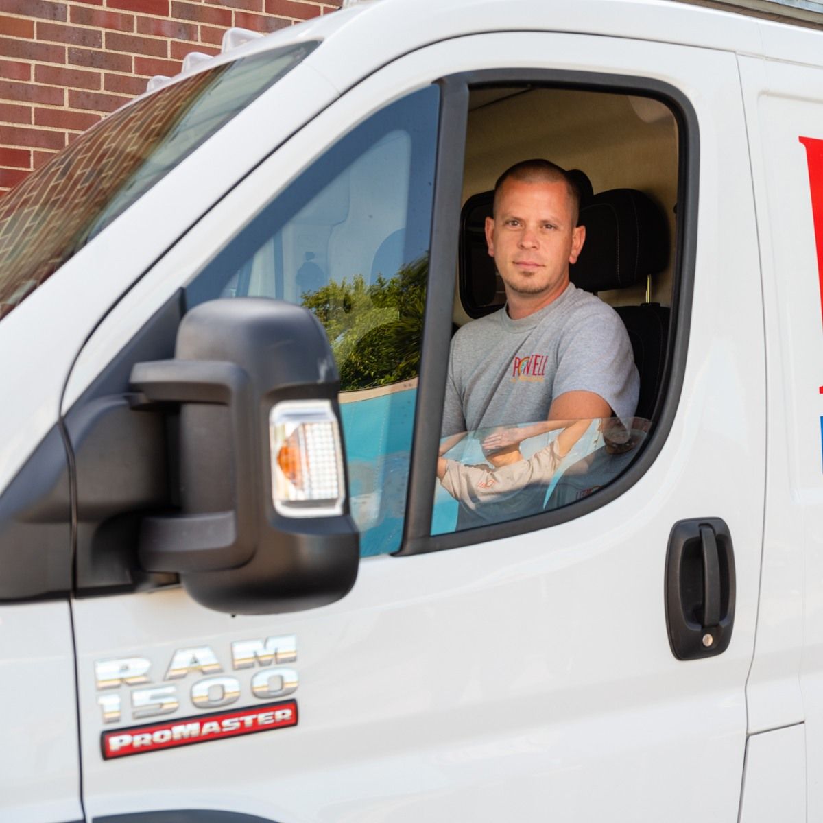 A man is sitting in the driver 's seat of a ram 1500 promaster van