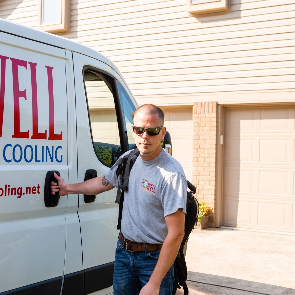 A man is standing in front of a well cooling van