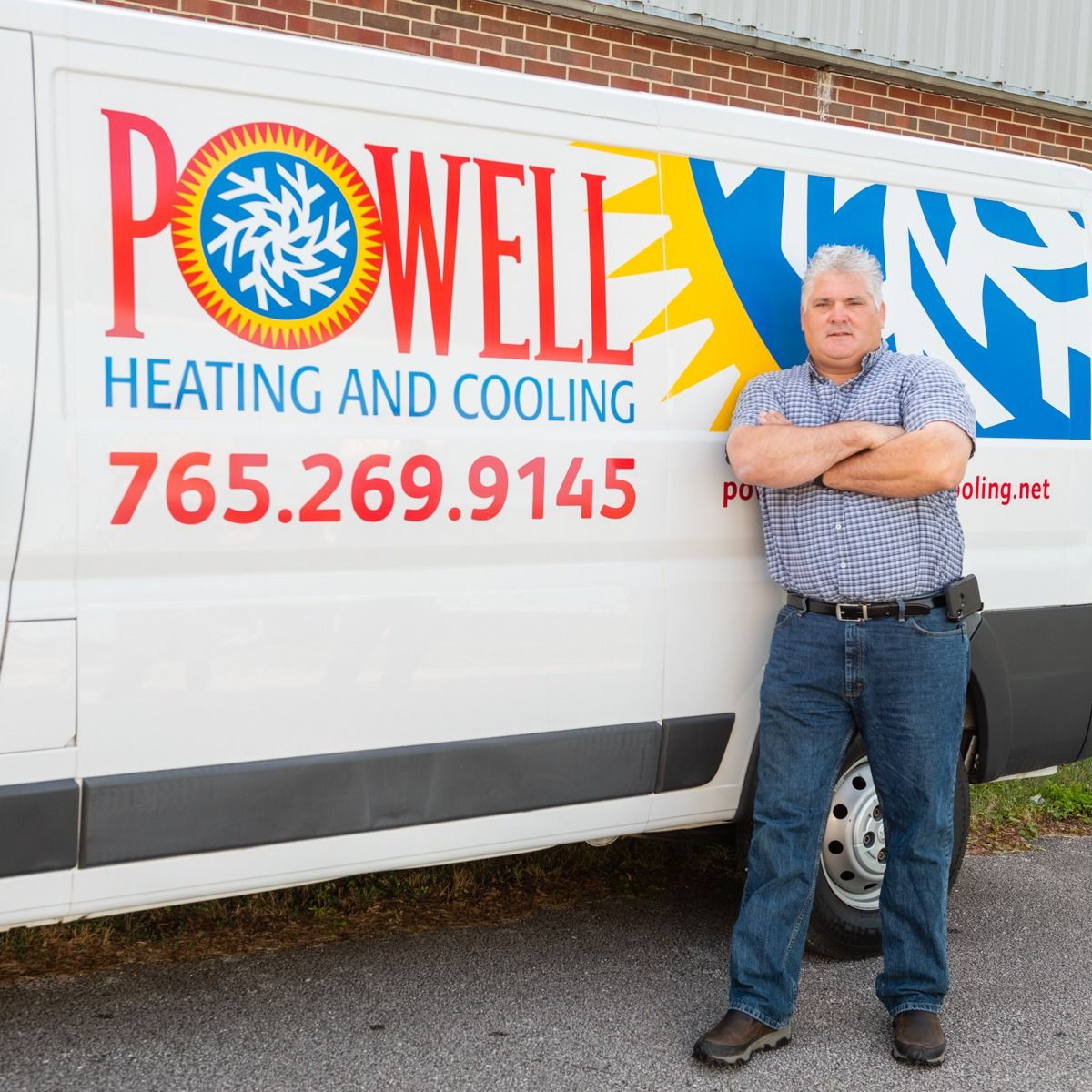 A man stands in front of a powell heating and cooling van