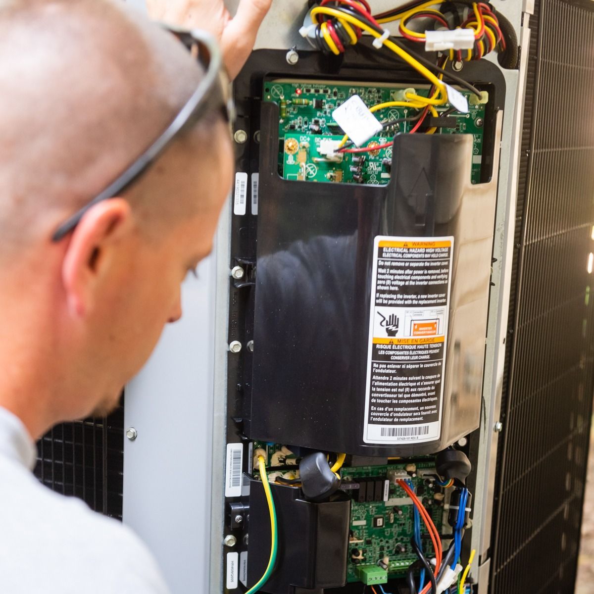 A man is looking at the inside of an air conditioner
