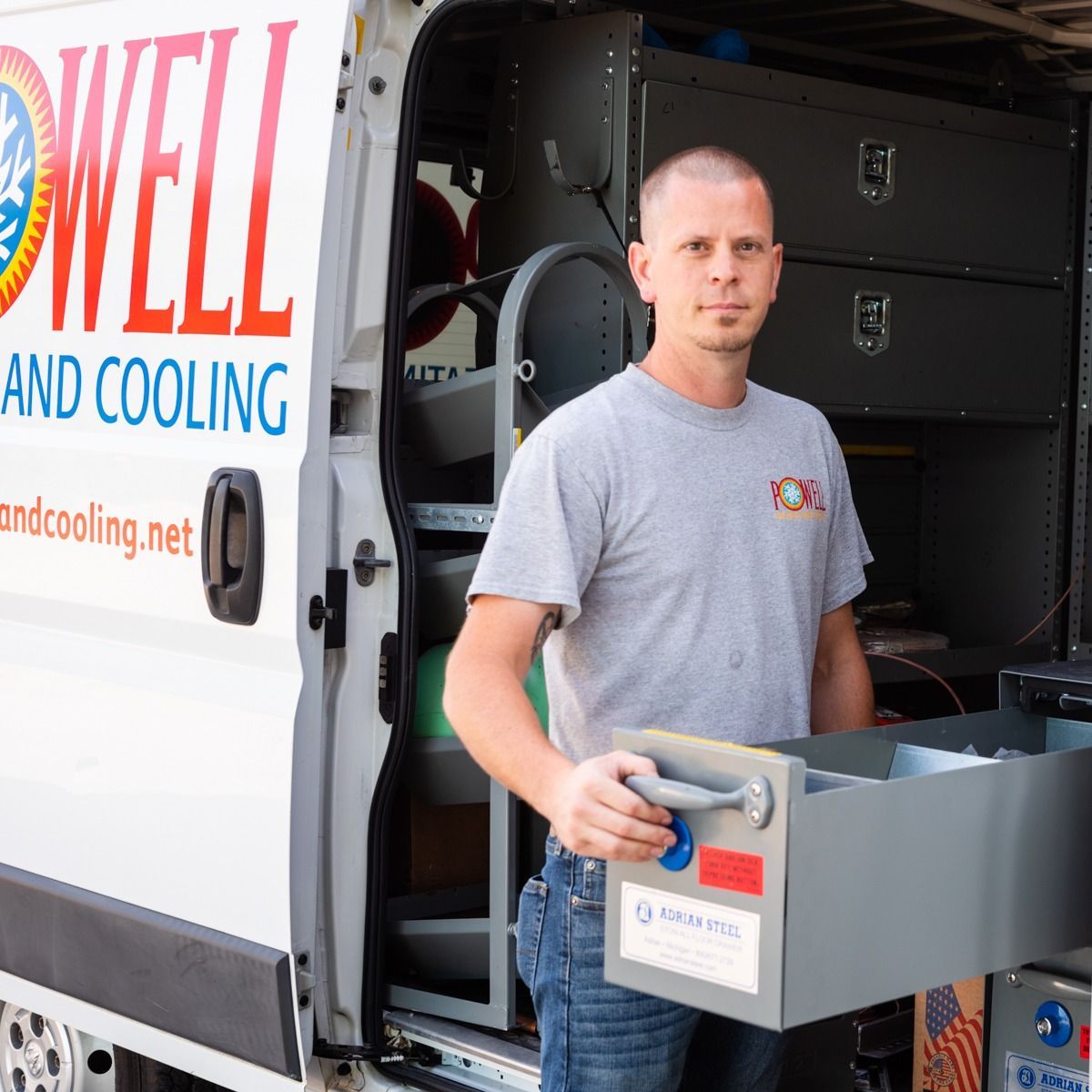 A man is standing in front of a well and cooling van