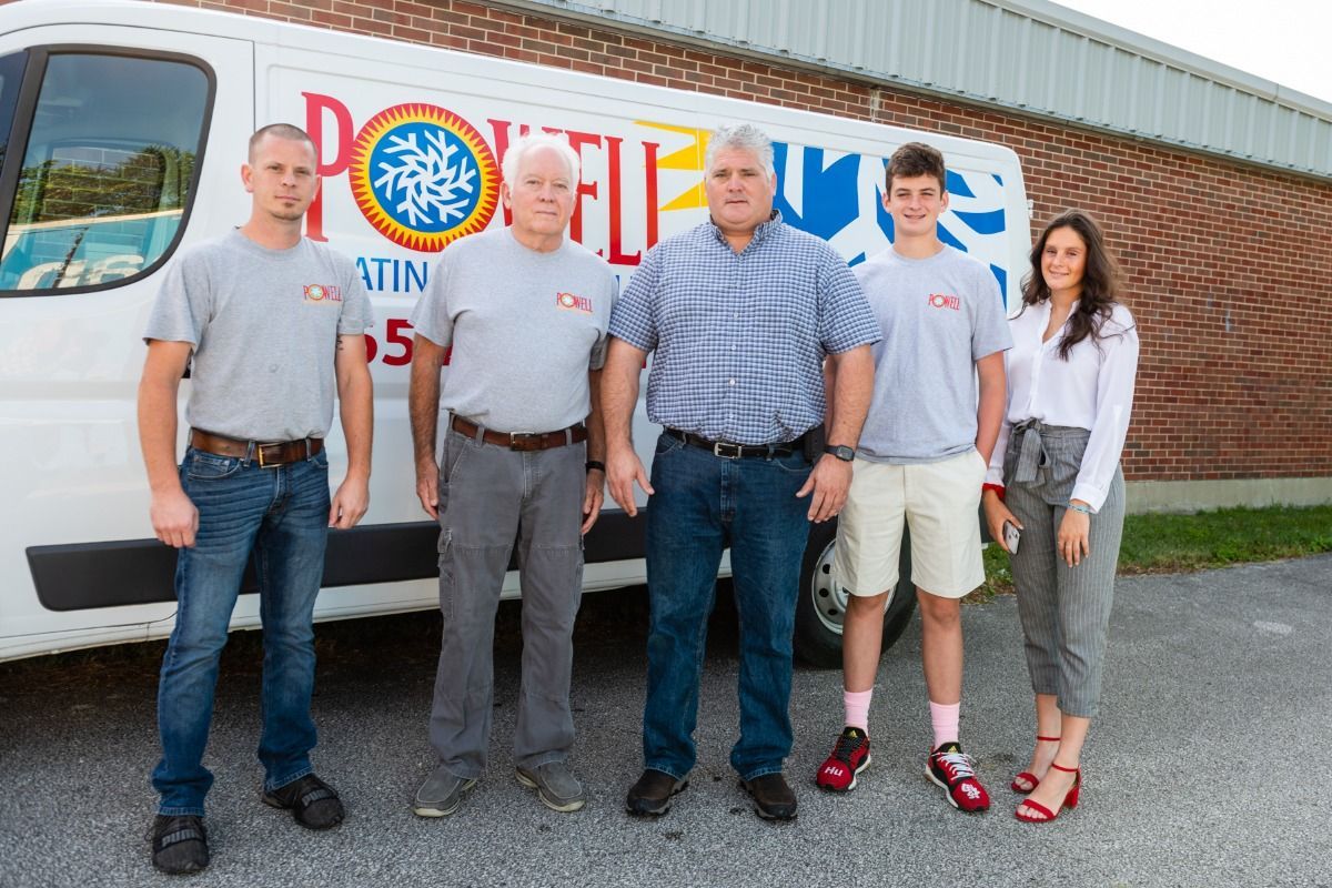 A group of people standing in front of a white van.