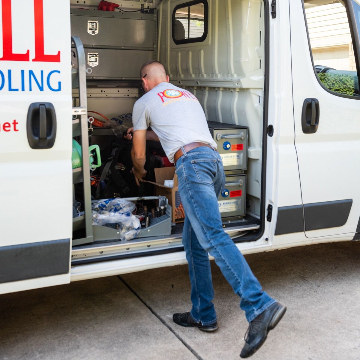 A man getting into a white van that says cooling