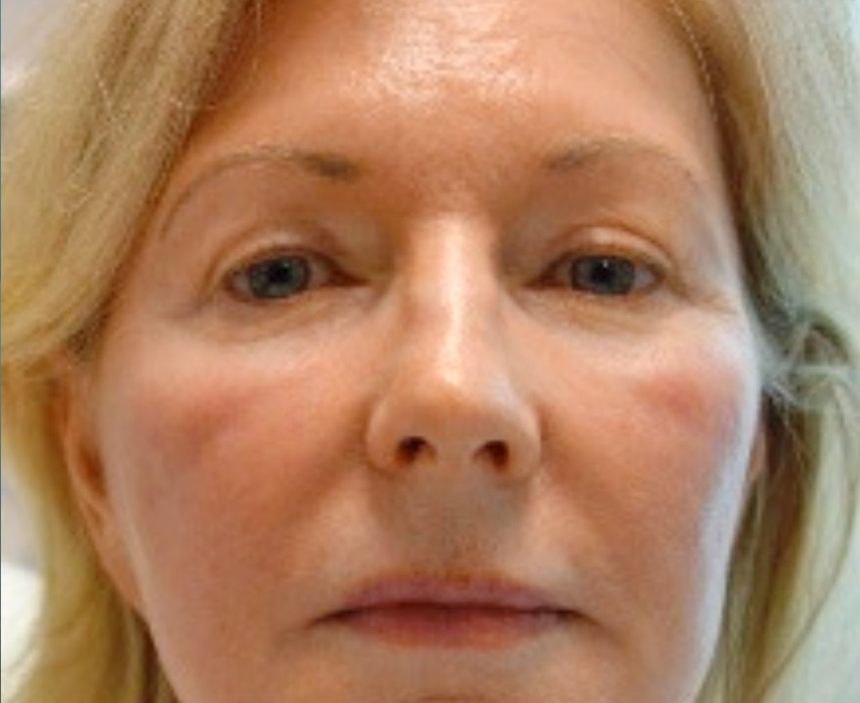 A close up of a woman's face with a serious look on her face