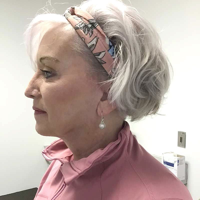 A woman wearing a headband and earrings is standing in a room
