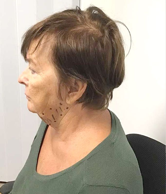 A woman in a green shirt is sitting in a chair