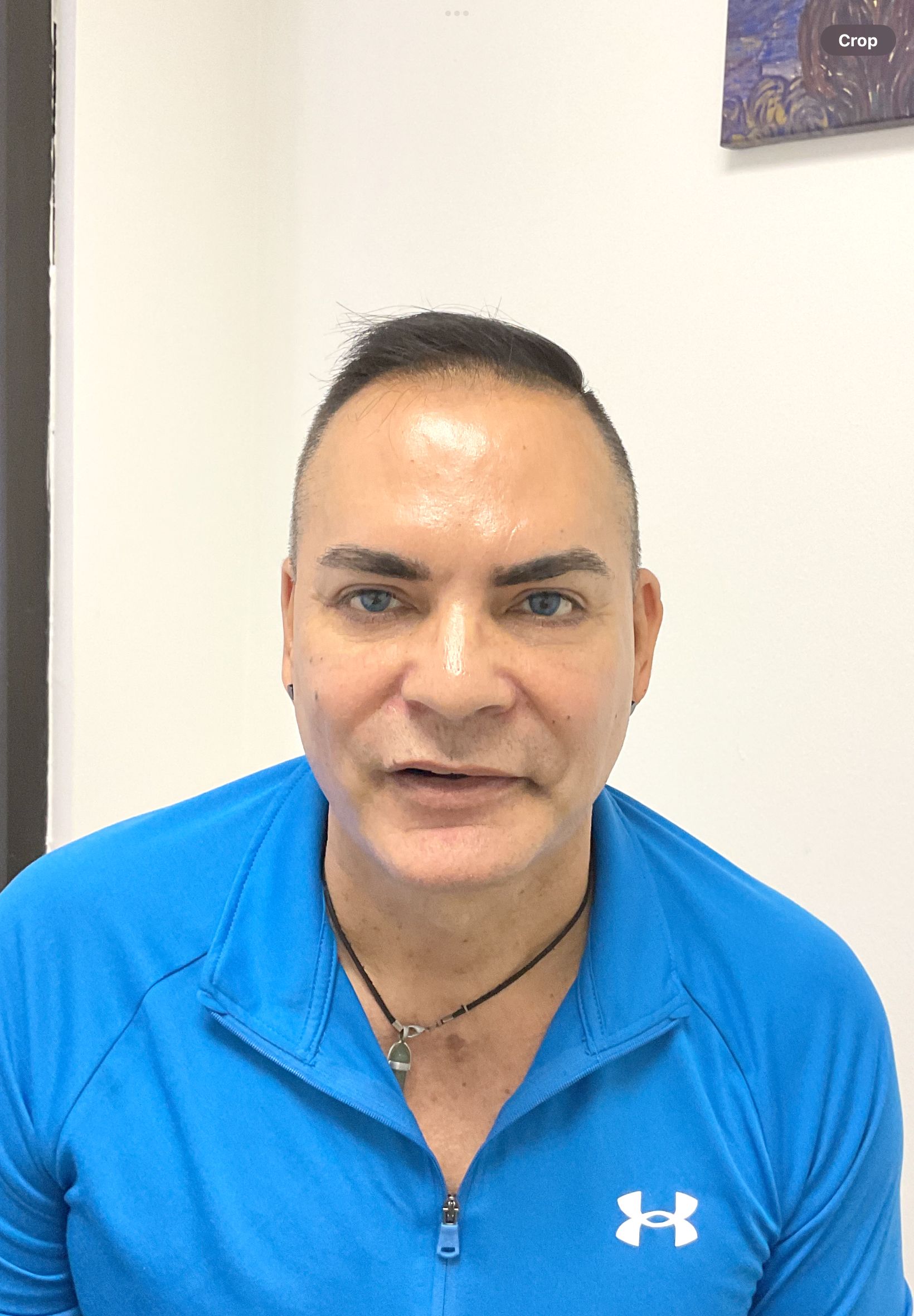 A man wearing a blue Under Armour shirt is looking at the camera