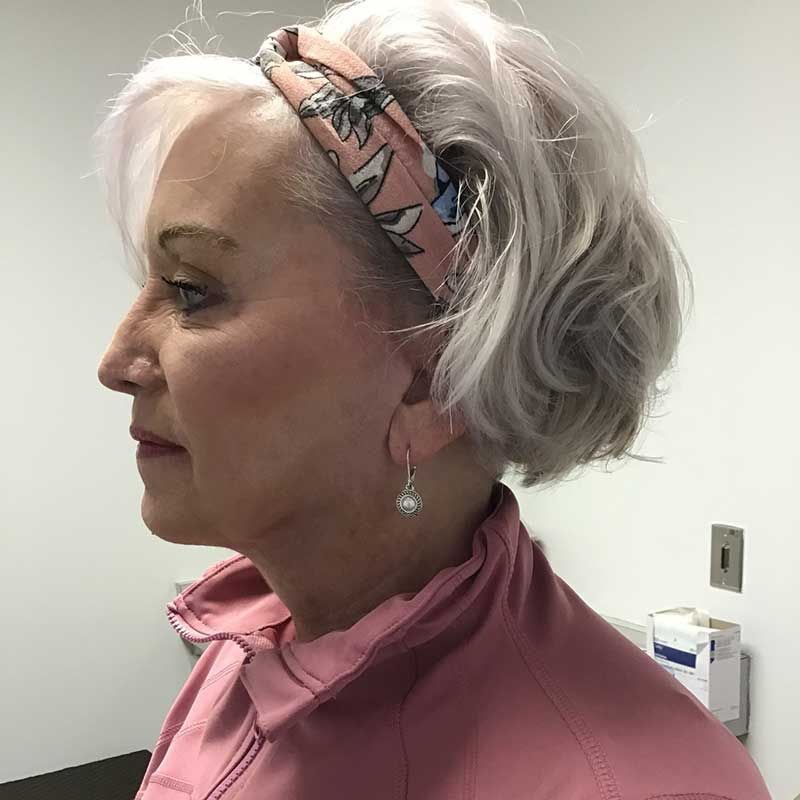 A woman wearing a headband and earrings is standing in a room
