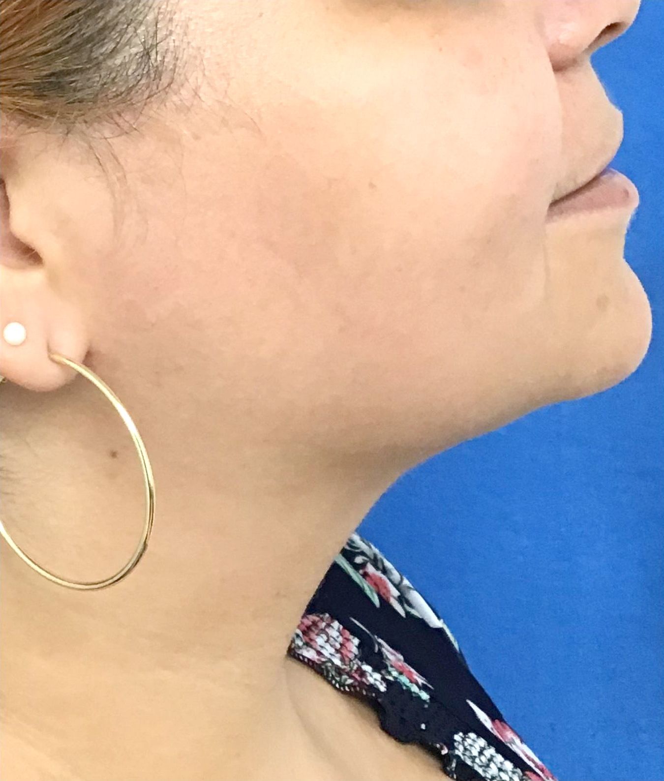 A close up of a woman's face with hoop earrings