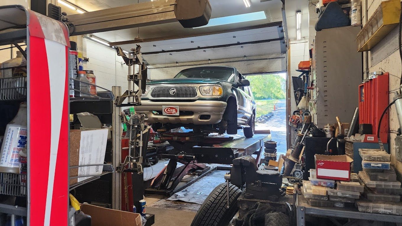 A truck is sitting on a lift in a garage.