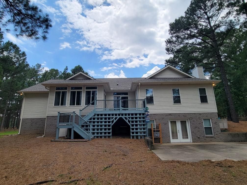 The back of a house with a blue deck and stairs