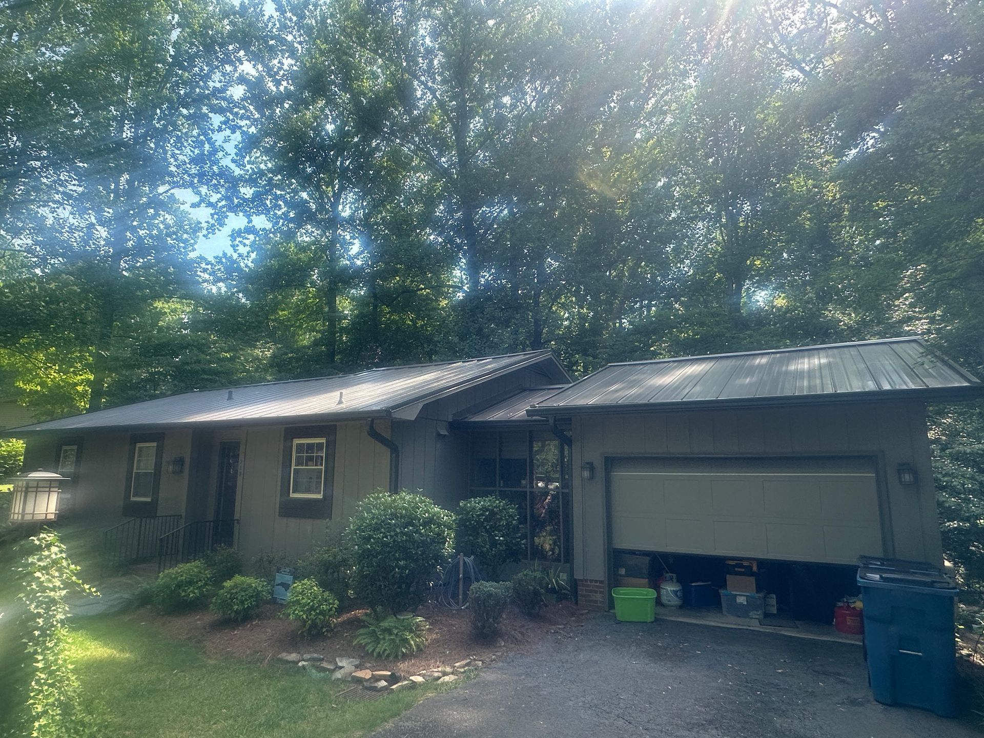 A house with a garage and trees in the background