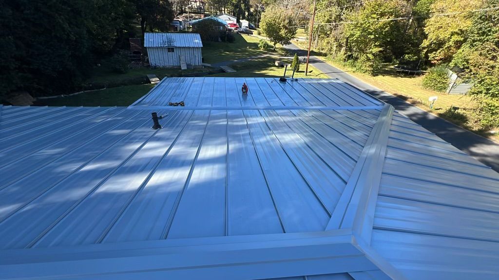 The roof of a house is being painted white.