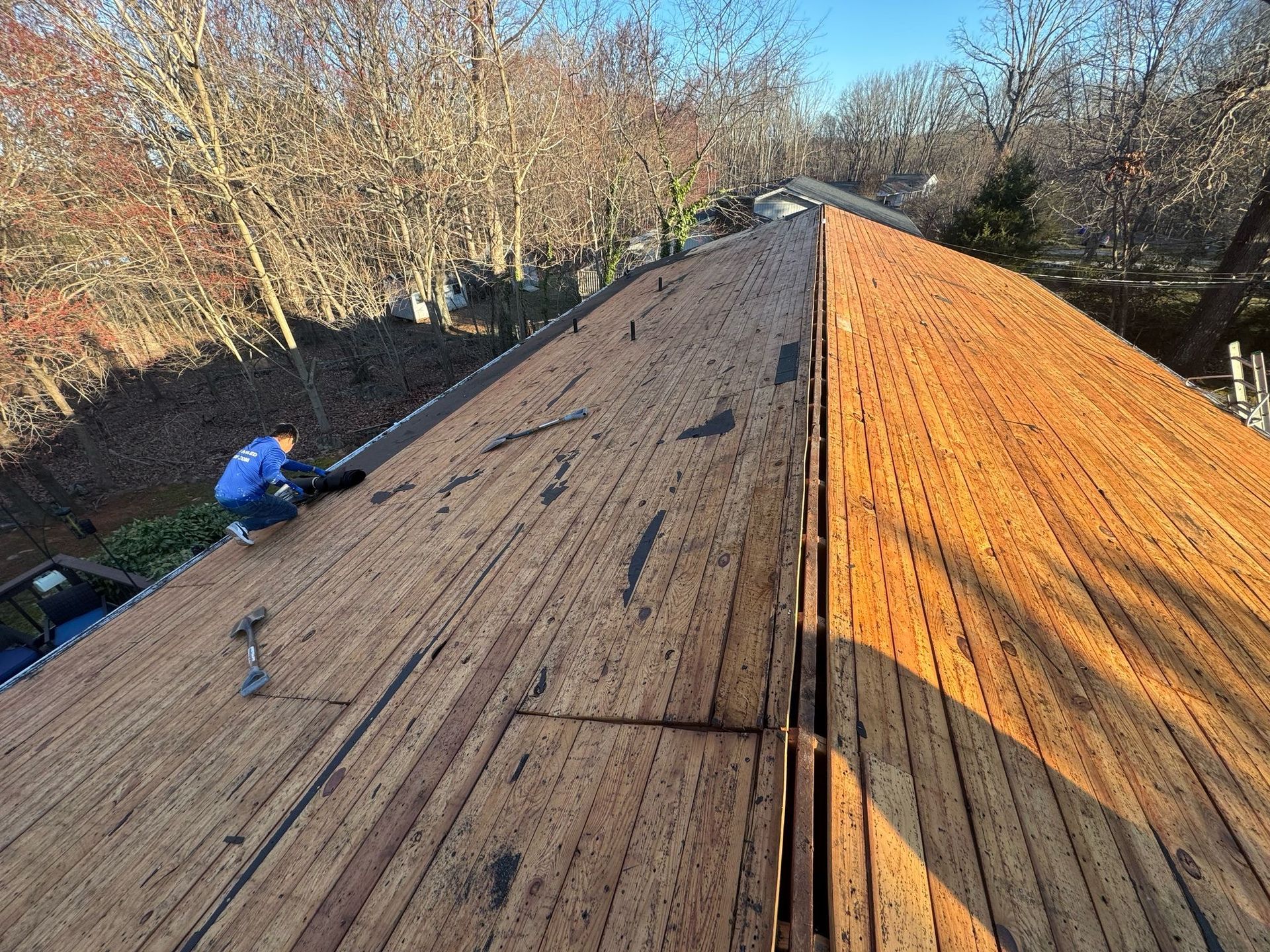 A man is working on the roof of a house.