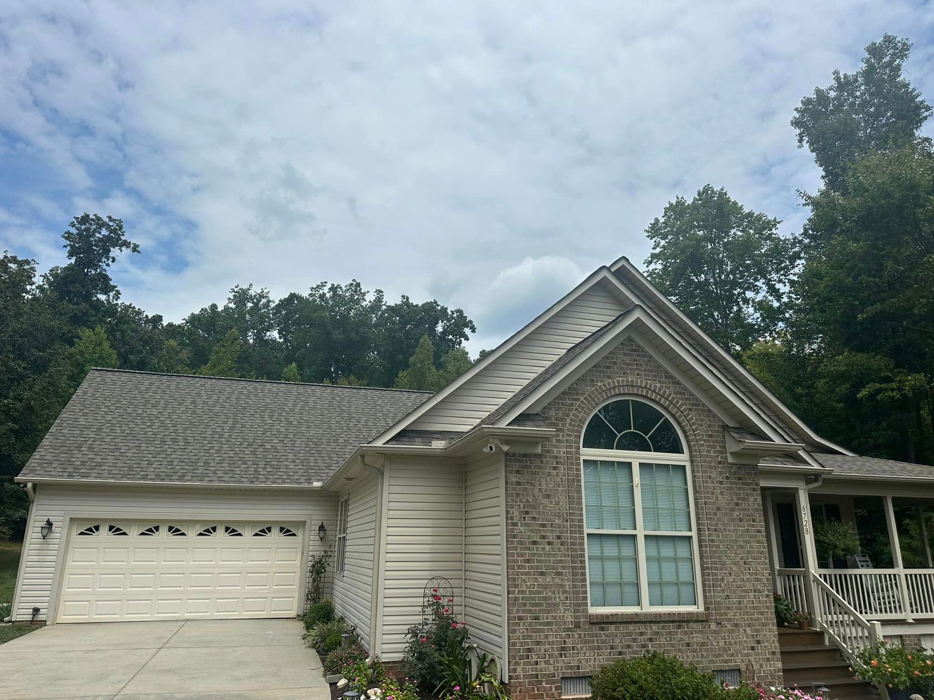A house with a gray roof and a white garage door