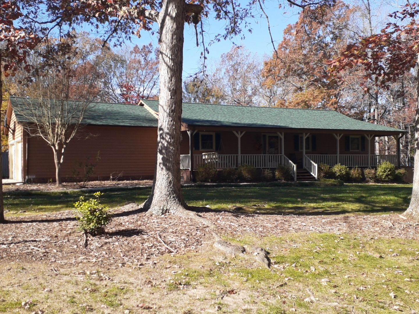 A brick house with a green roof and a porch
