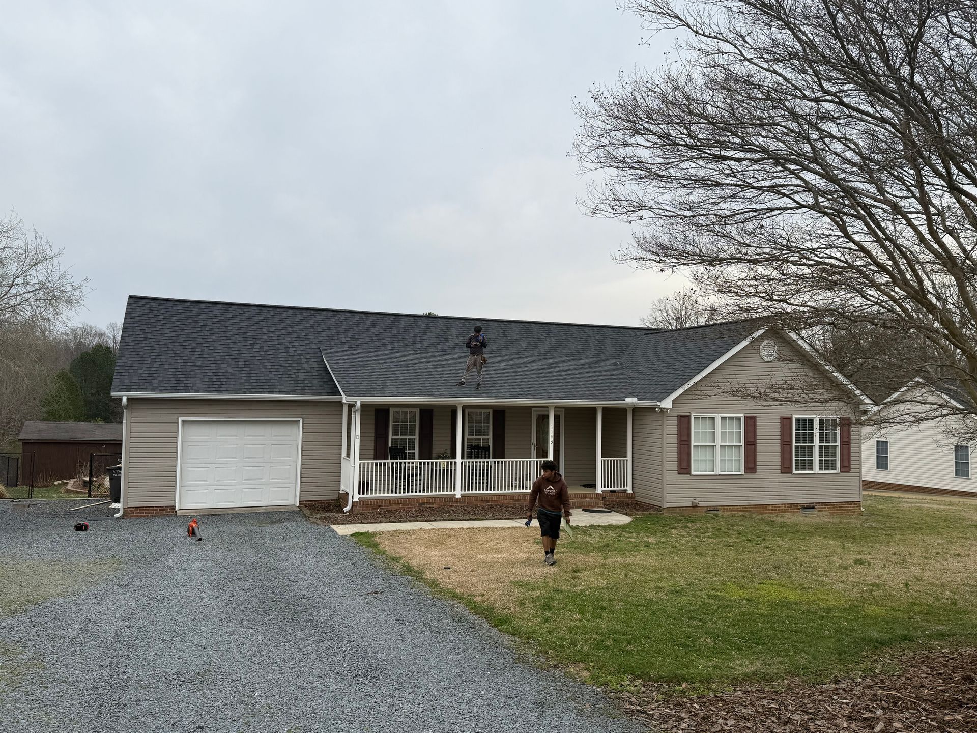 A man is standing on the roof of a house.