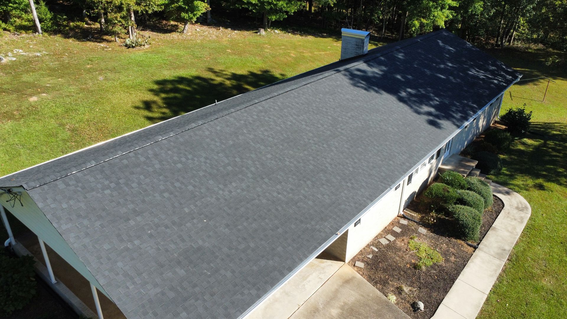 An aerial view of a house with a black roof.