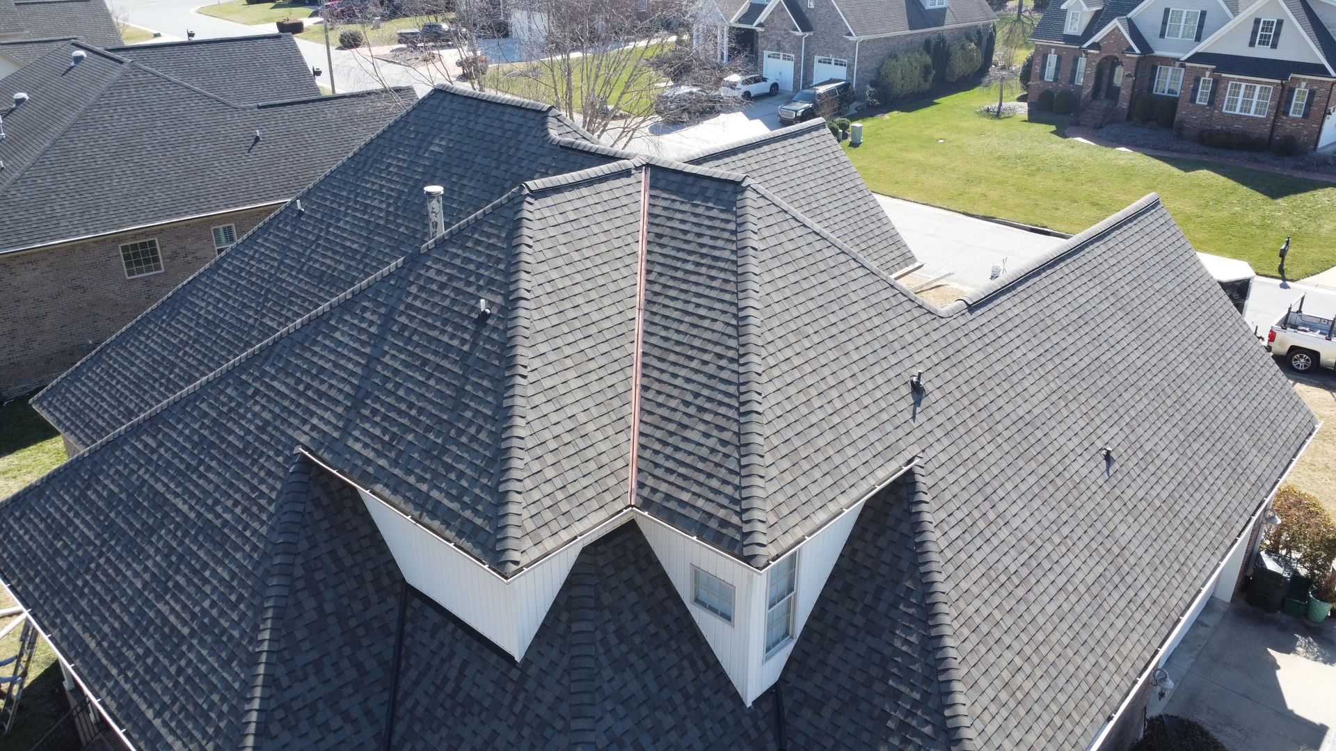 An aerial view of a house with a black roof.