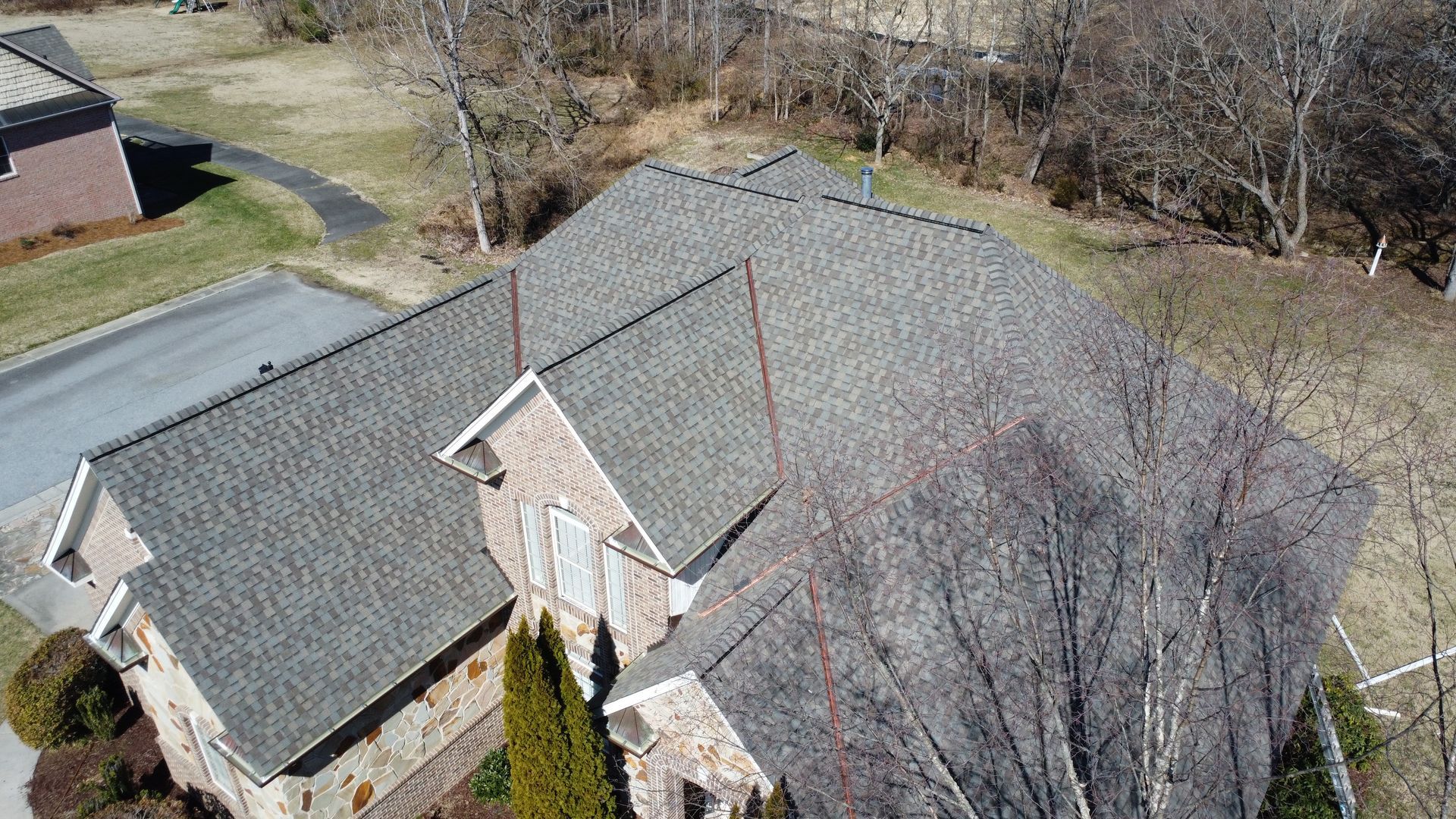 An aerial view of a house with a roof that is covered in shingles.