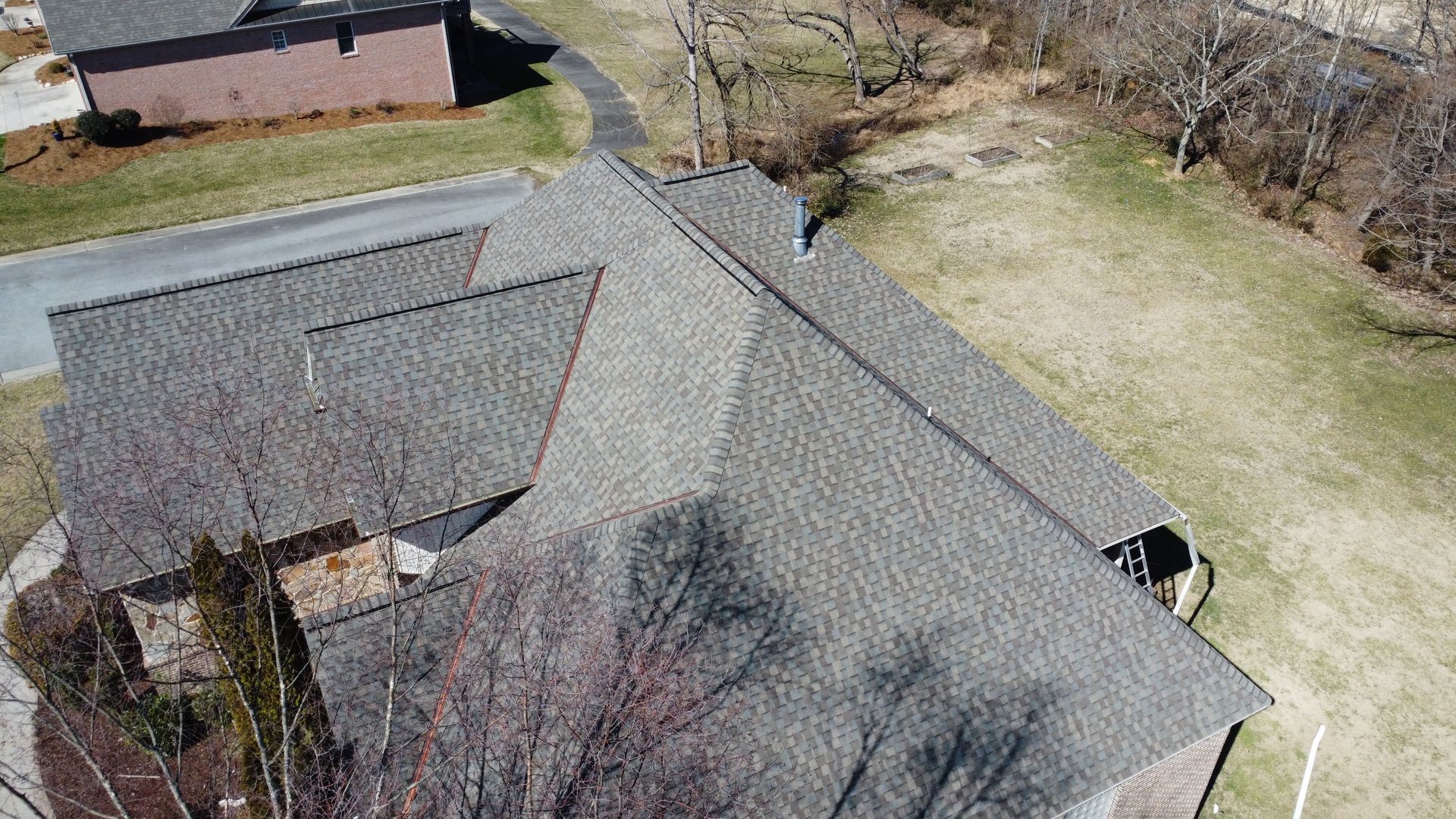 An aerial view of a house with a roof that is being repaired.