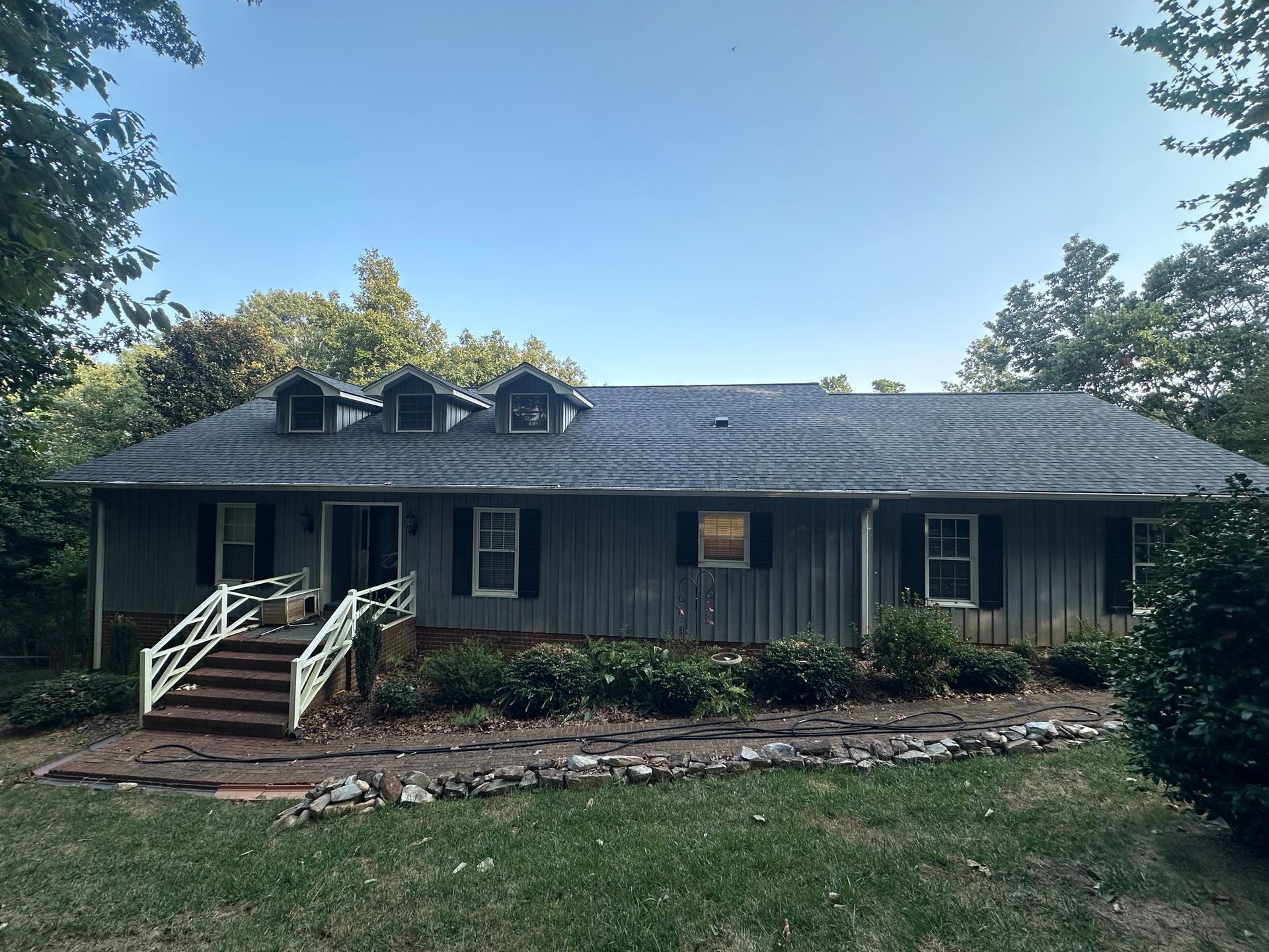 A large house with a blue roof and black shutters