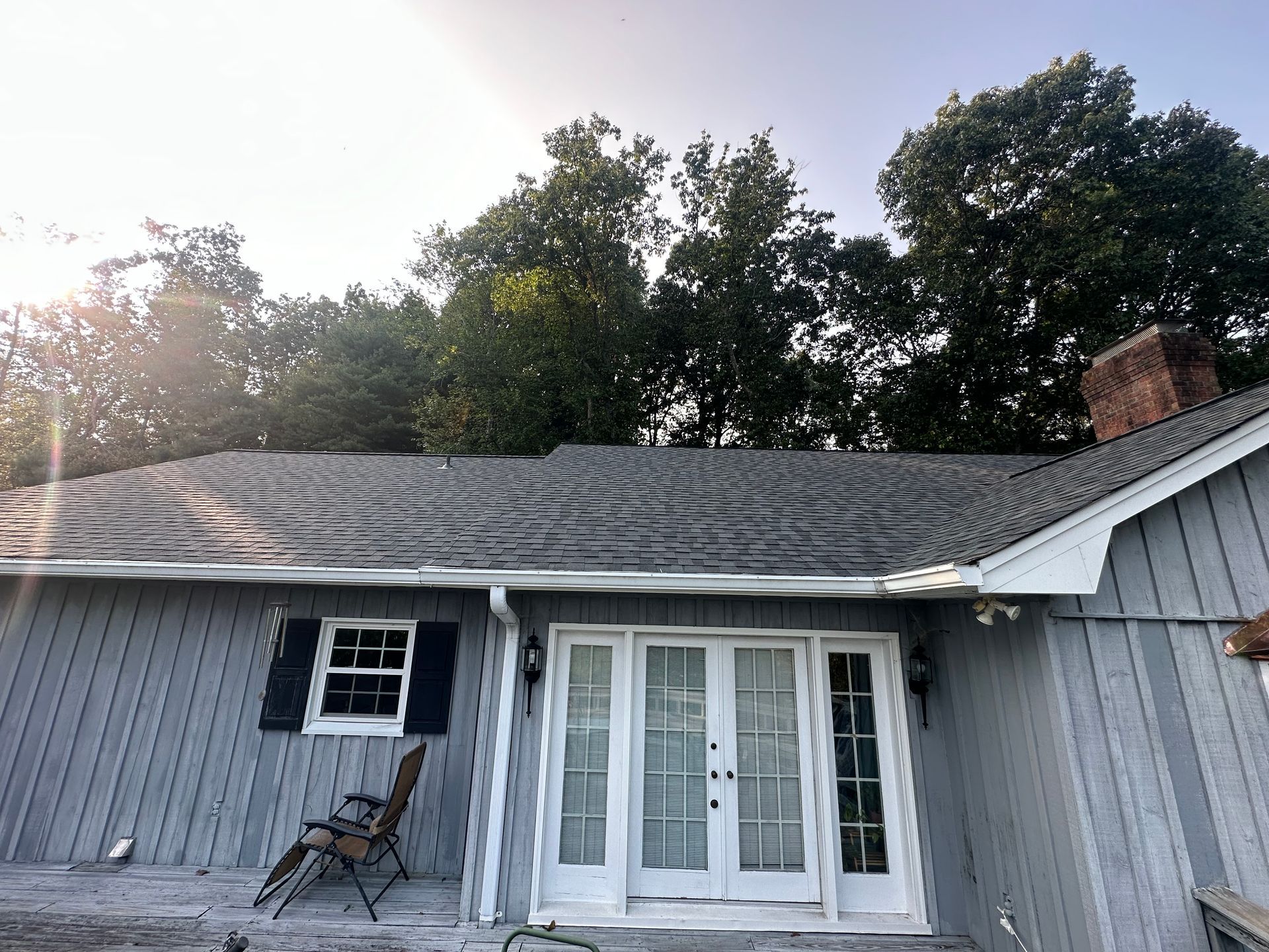 A house with a sliding glass door and a chair on the porch.