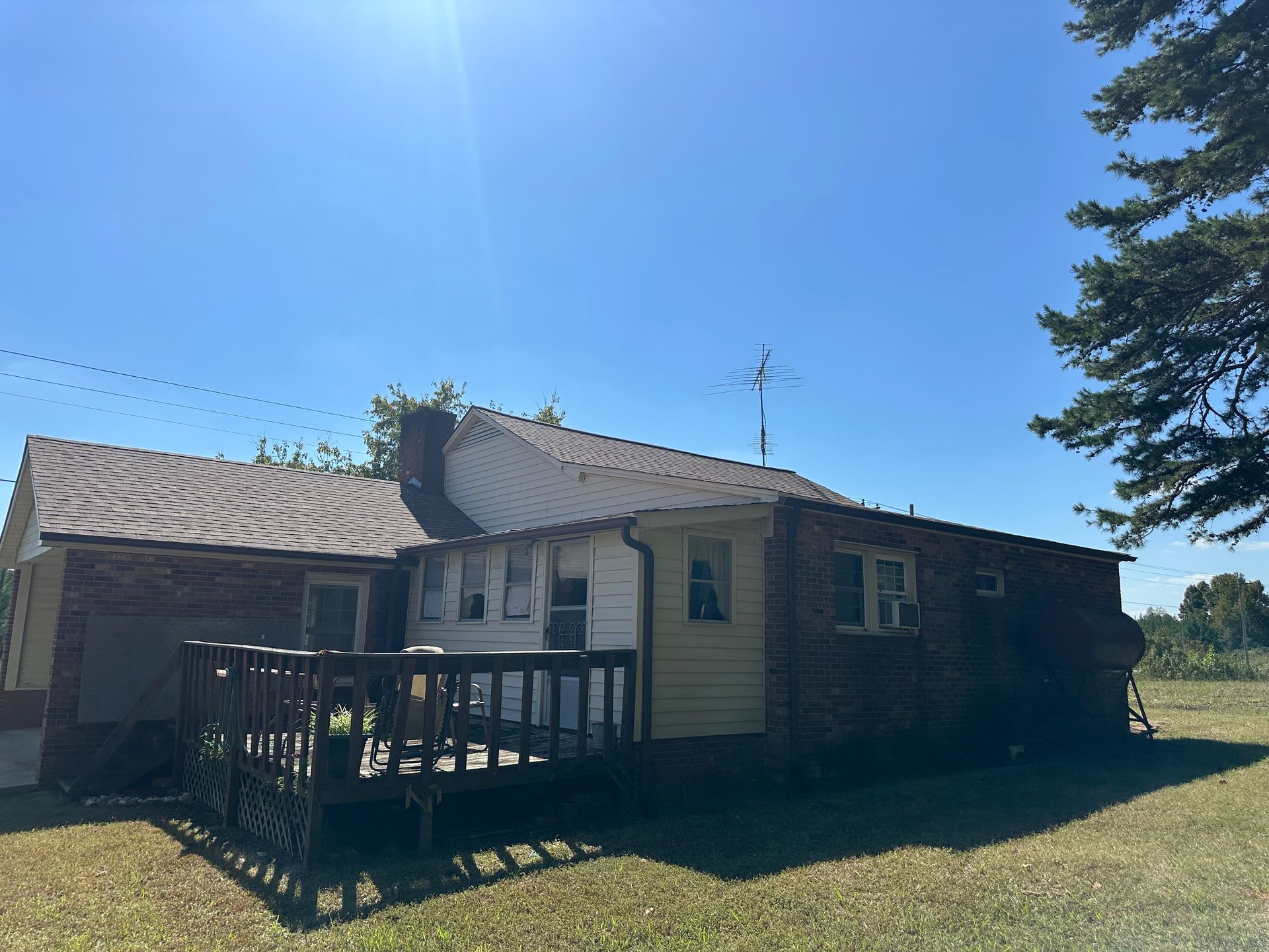 A house with a deck and a blue sky in the background