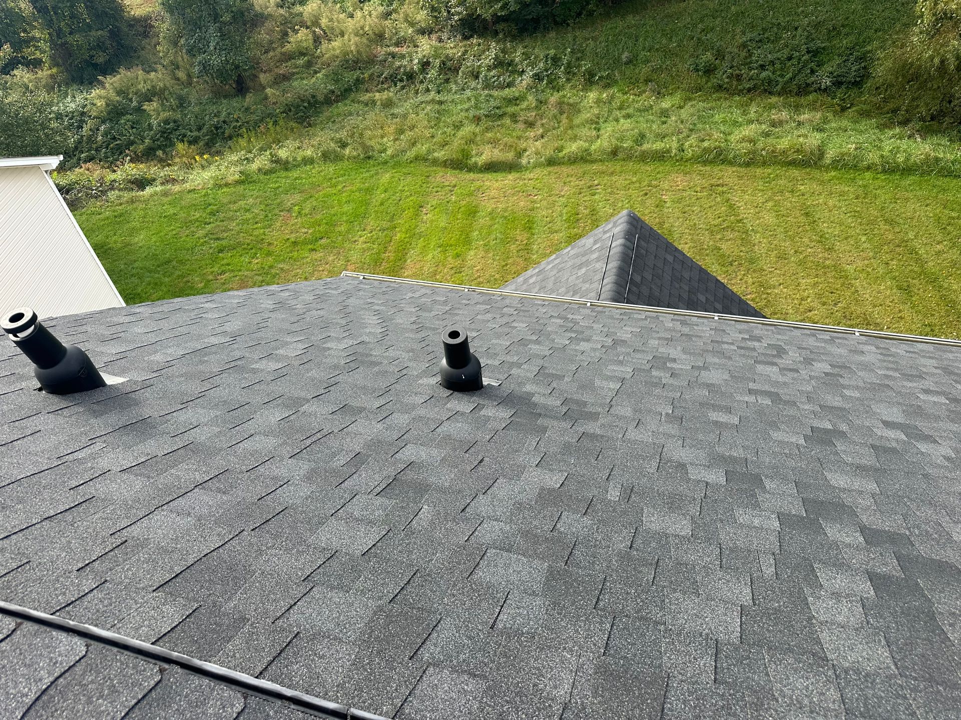 A roof with a pyramid shaped roof and a field in the background.