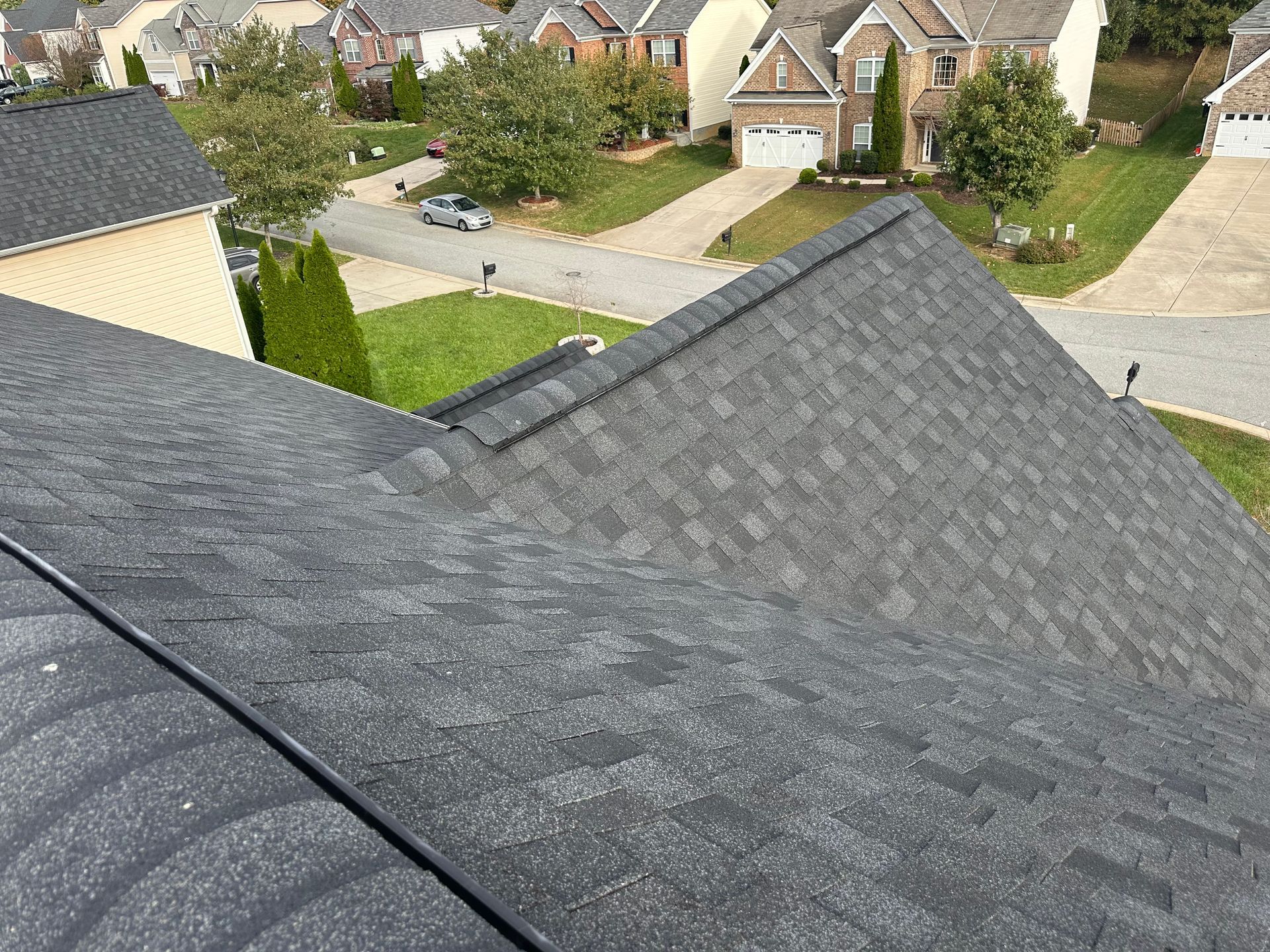 An aerial view of a roof of a house in a residential area.