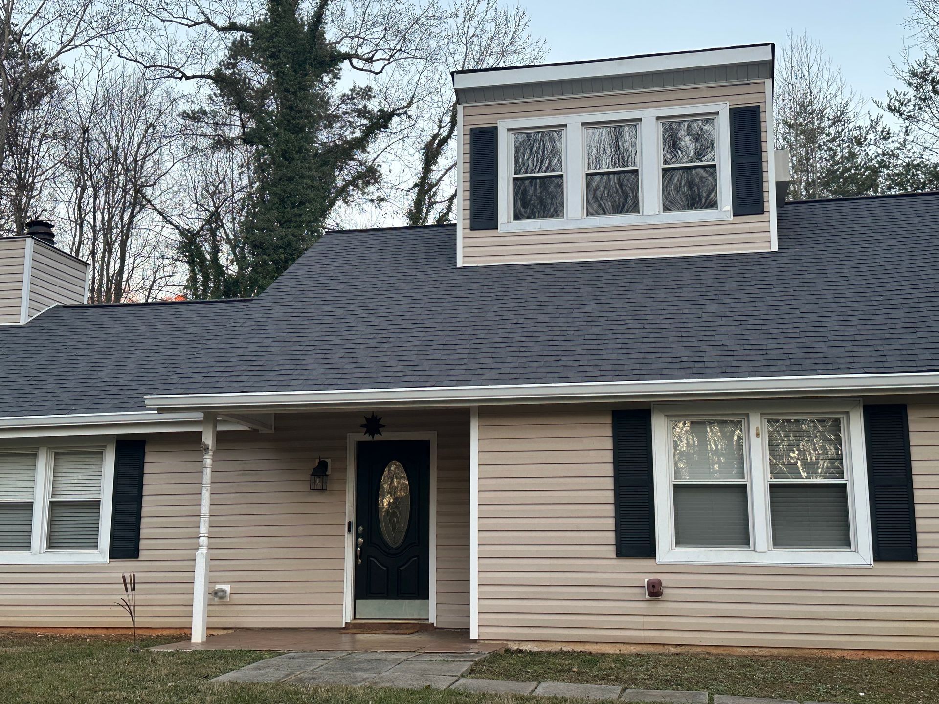 A house with a gray roof and black shutters