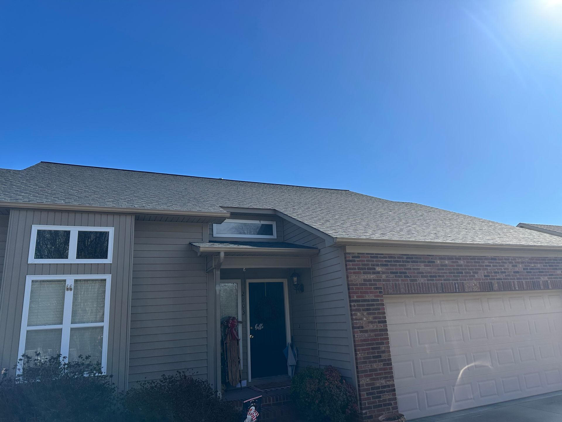A house with a gray roof and a blue sky in the background.