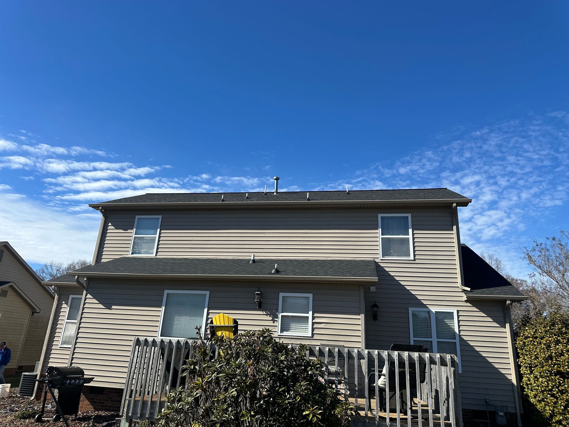 The back of a house with a blue sky in the background.