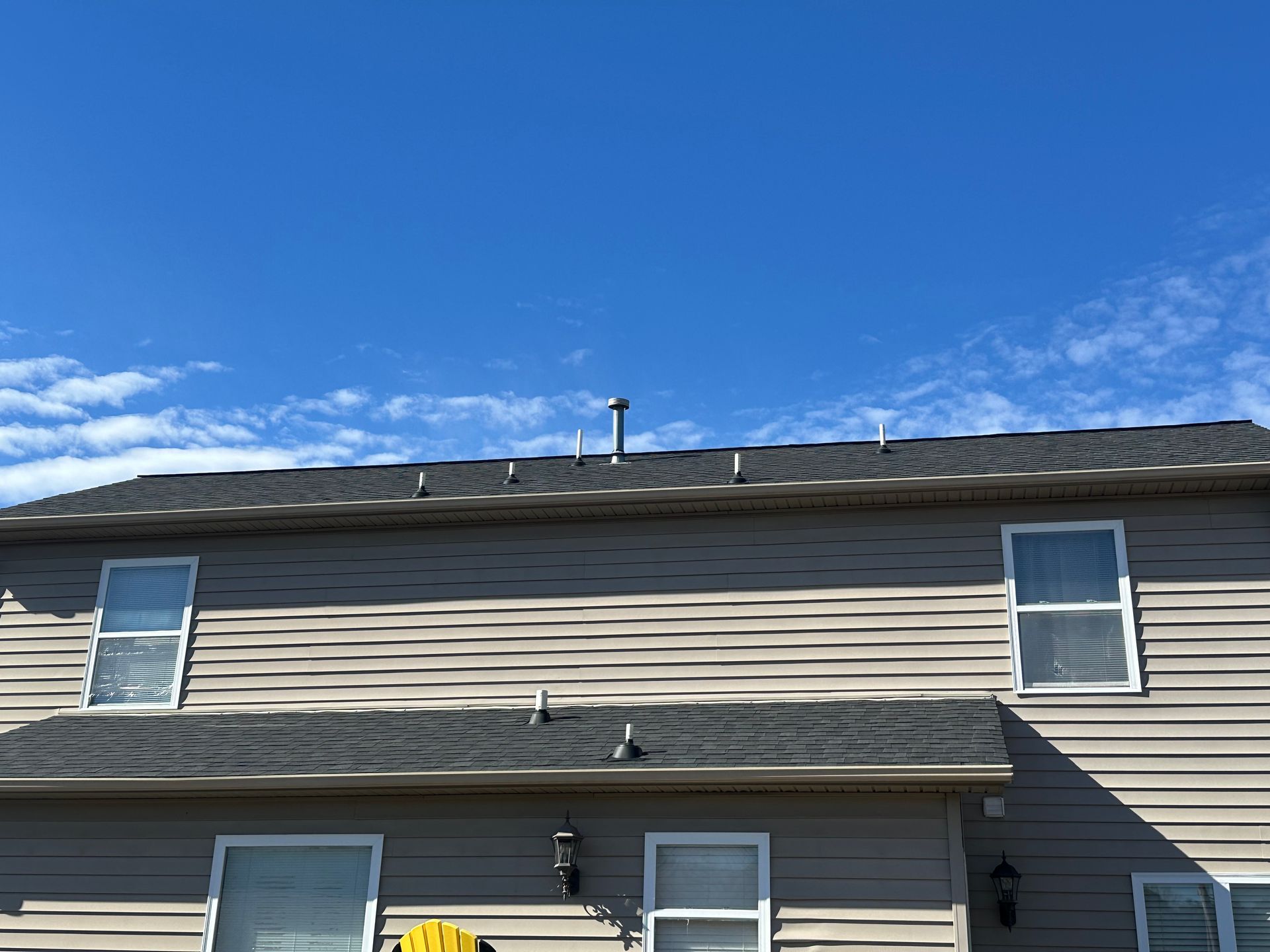 The roof of a house with a blue sky in the background